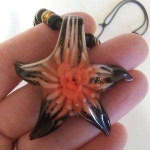 glass starfish shaped pendant with a flower inside